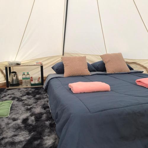 a bed in a tent with pillows on it at Hangout Khaokho รีสอร์ตG3 in Phetchabun