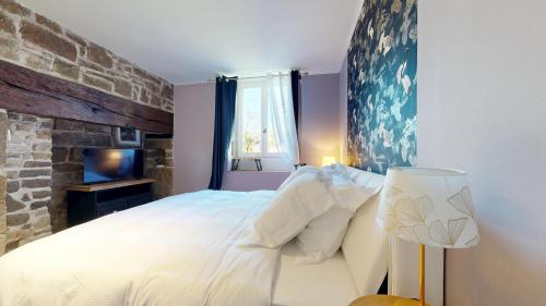 una camera da letto con un letto grande e un muro di mattoni di Appartement Standing Sauna Privé a Brive-la-Gaillarde