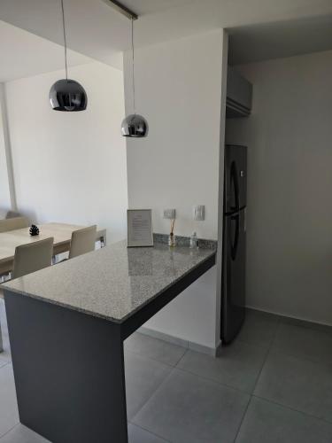 a kitchen with a granite counter top and a refrigerator at Arévalo - D2 in Cipolletti