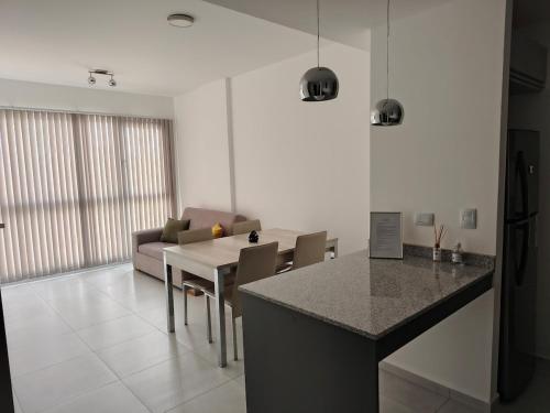 a kitchen and living room with a table and a couch at Arévalo - D2 in Cipolletti