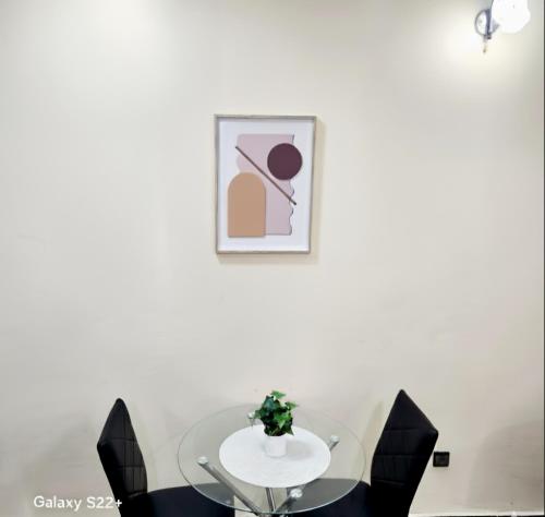 ヤウンデにあるClimatisation - Wi-Fi gratuitのダイニングルーム(ガラステーブル、黒い椅子付)