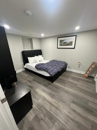 Basement في برامبتون: غرفة نوم مع سرير وأرضية خشبية