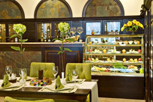 a restaurant with two tables and chairs and a buffet of food at Hotel Prezydencki 4-star in Rzeszów