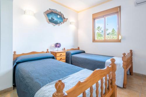 a bedroom with two beds and a window at Es Marroig Villa y Spa in Llucmajor