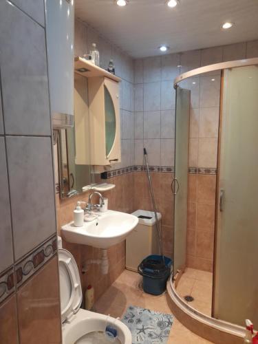 a bathroom with a toilet and a sink and a shower at Belindo in Varna City