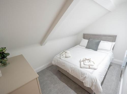 a white bedroom with a bed with towels on it at Spacious Two Bed Central Sunniside Penthouse Apartment in Sunderland