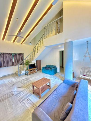 una sala de estar con un sofá y una mesa en Aashiyana Villa - The Dream Stays ll Jacuzzi ll Pvt Big Pool ll Garden ll 3 Ac Rooms ll Gazebo, en Lonavala