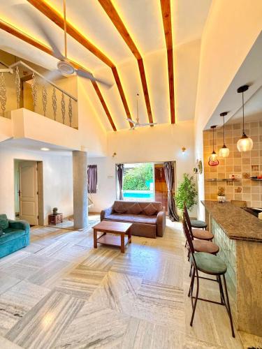 a living room with a couch and a table at Aashiyana Villa - The Dream Stays ll Jacuzzi ll Pvt Big Pool ll Garden ll 3 Ac Rooms ll Gazebo in Lonavala