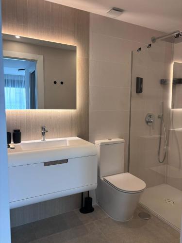 a bathroom with a sink and a toilet and a mirror at Premium Alicante in Gran Alacant