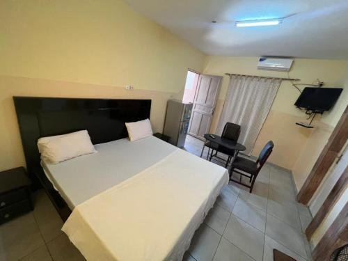 a bedroom with a large white bed and a desk at Teranga Sénégal Chez Mimi in Toubab Dialaw