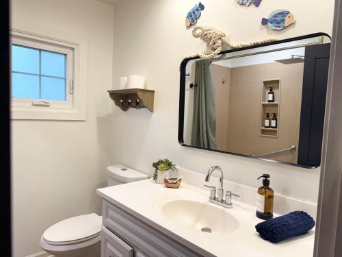 a bathroom with a sink and a mirror at The Float House at Buckeye Lake - Hot Tub - Patio - Privacy in Thornville