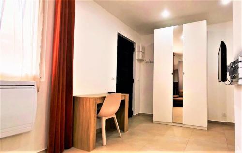 una cucina con tavolo, sedia e specchio di Cosy et Chill studio Proche Paris et le Bourget , Ideal long séjour pour Couples et Professionnels a Drancy