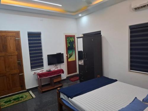 a bedroom with a bed and a flat screen tv at greenview homestay Mayyil in Parassinikadavu
