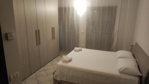 Un dormitorio con una cama blanca con dos toallas encima. en Holiday House Iolo, en Prato