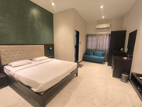 a bedroom with a bed and a blue couch at Hotel Shubham Inn in Thane