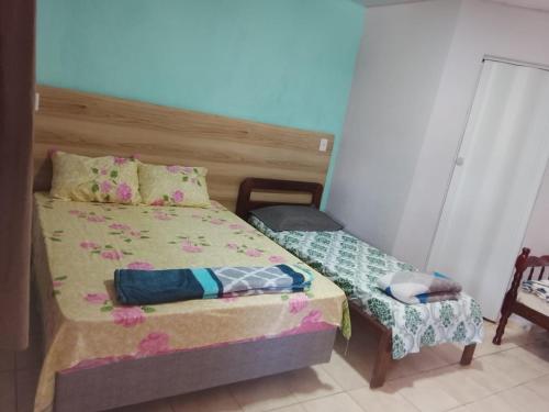a small bedroom with a bed and a chair at Pousada Encantos de Paripueira in Paripueira