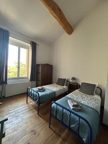 a bedroom with two beds and a window at Domaine Les Salices in Azille