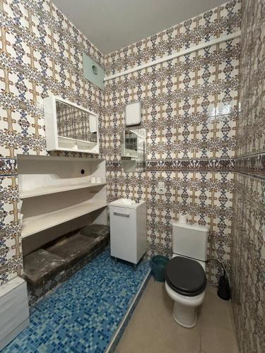 a bathroom with a toilet and a tiled wall at Domaine Les Salices in Azille