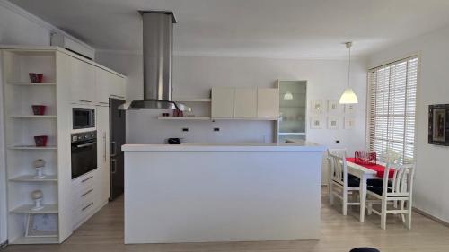 a kitchen with a white counter and a table at Foleza in Korçë
