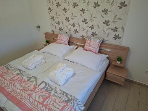 a bedroom with a bed with towels on it at Napsugár Wellness Apartman in Újudvar