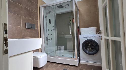 a bathroom with a washing machine and a washer at Foleza in Korçë