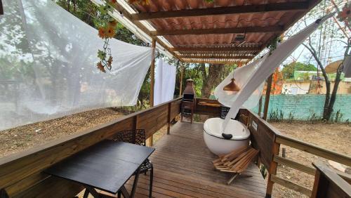 a porch with a bath tub sitting on a deck at Minicasa Brasileira in Sorocaba