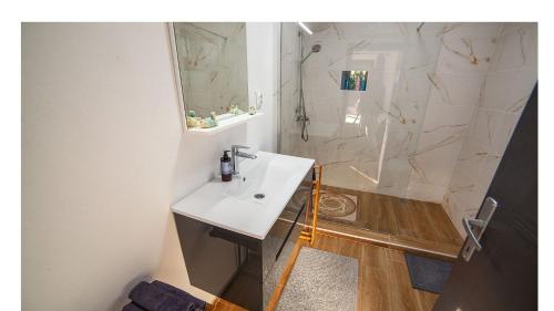 a bathroom with a white sink and a shower at Valley of Bikic in Bikić Do