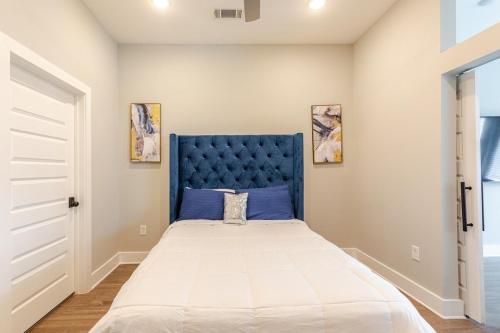 a bedroom with a large bed with a blue headboard at Luxury Hideout in Decatur