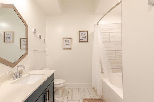 a white bathroom with a tub and a toilet and a sink at Luxury Hideout in Decatur
