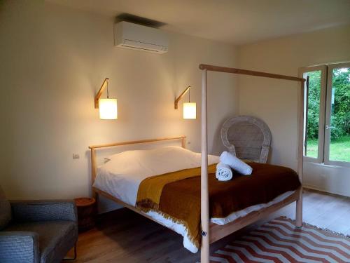 a bedroom with a canopy bed and a chair at Petit Vaure in Ruch