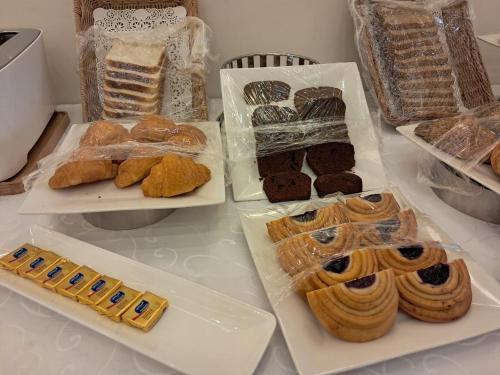 a table topped with different types of pastries and desserts at Tura Hotel AlNuzha- فندق ترى النزهة in Riyadh