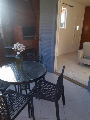 a table and chairs with a vase of flowers on it at Casa em Petrópolis in Petrópolis