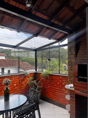 a patio with a table and chairs and windows at Casa em Petrópolis in Petrópolis