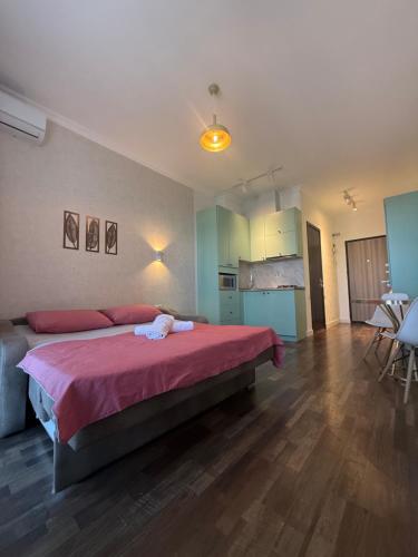 a bedroom with a large bed with a pink blanket at Gumbati 173 in Batumi