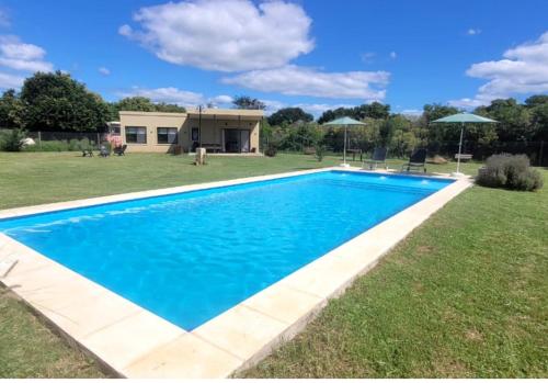 ein großer blauer Pool im Hof in der Unterkunft Casa de Campo Vuelta de Obligado in Vuelta de Obligado