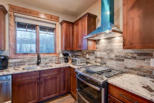 a kitchen with wooden cabinets and a stove top oven at Happy Trails at Eagles Nest in Elk Park