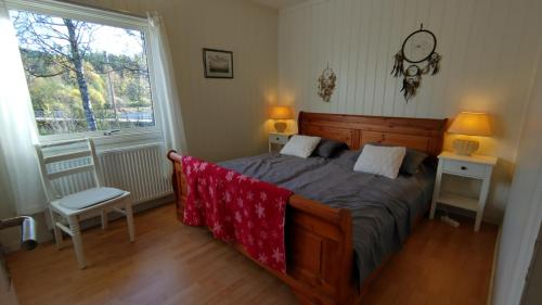 a bedroom with a bed and two tables and a window at Gästhus i Röjdåfors in Östmark