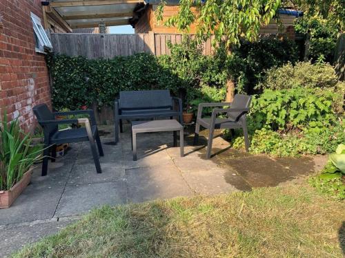 a group of chairs and tables in a garden at Comfy Holiday Home & Beach Hut in Sutton on Sea