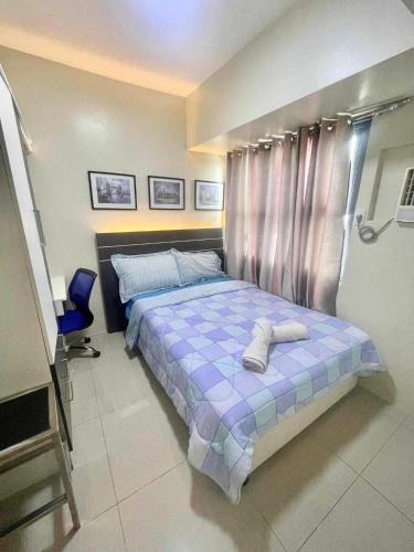 a bedroom with a bed with two towels on it at Horizons 101 Condominium in Cebu City