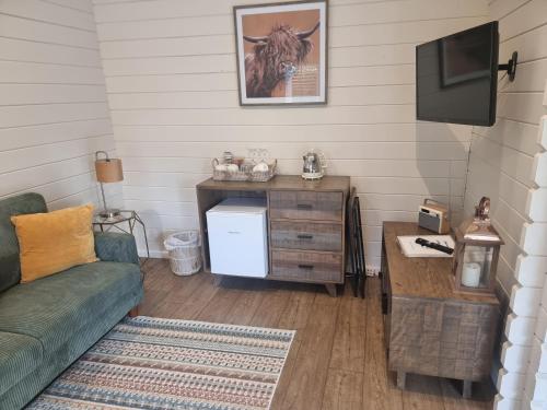 a living room with a couch and a tv at Willow House B&B in West Wittering