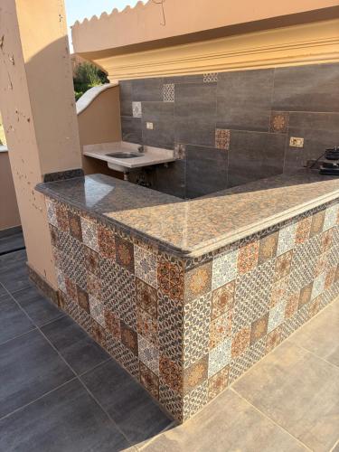 - une cuisine avec un comptoir en carrelage et un évier dans l'établissement Townhouse, au Caire