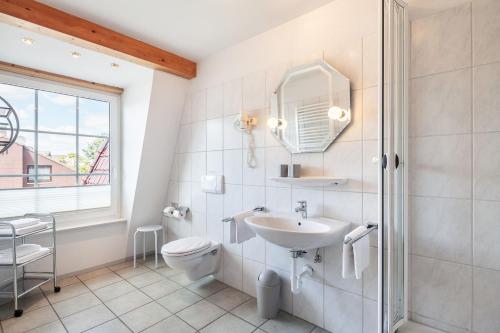 a bathroom with a sink and a toilet and a window at Gästehaus Daheim in Scharbeutz