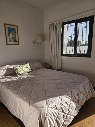 een bed in een slaapkamer met een groot raam bij Europe Sun Bungalow in Maspalomas