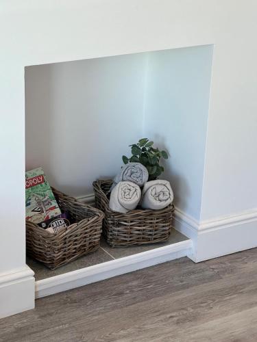 two baskets and a plant on a shelf in a room at Bright 2 Bedroom Apartment With Parking in Nottingham