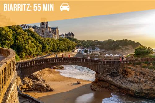 a bridge over a river with people walking on the beach at Cocon - Hyper Centre - Clim - Wifi in Dax