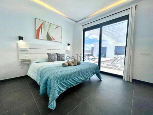 een slaapkamer met een bed en een groot raam bij Pipa Costa in Costa Teguise