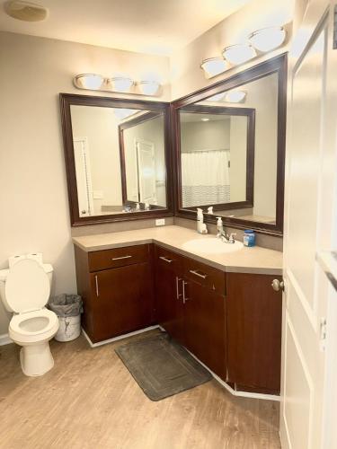 Un baño con inodoro, lavabo y espejo. en Luxe Haven, en Atlanta
