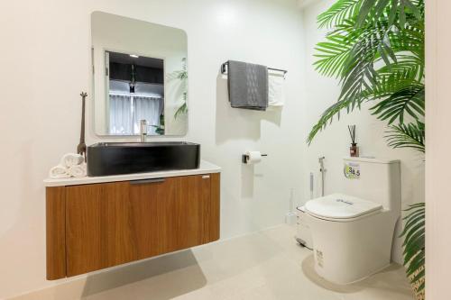 Un baño con lavabo, inodoro y espejo. en SunMui Pool Villa - 7 Bedrooms - Old town, en Chiang Mai