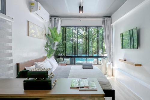a living room with a table and a large window at SunMui Pool Villa - 7 Bedrooms - Old town in Chiang Mai