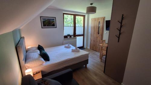 a small bedroom with a bed and a window at Sosnowy Zakątek Piwniczna in Piwniczna